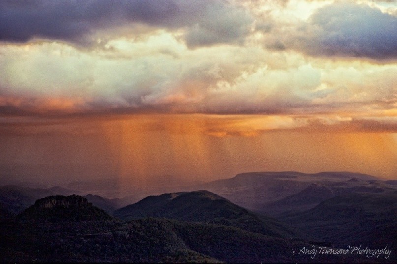 Afternoon sunlight catches rain tendrils in Mt Kaputar National Park.