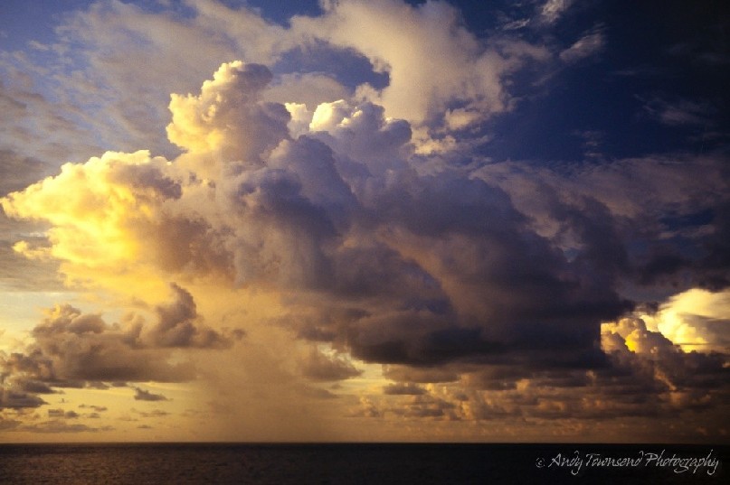 An afternoon rain storm in Darwin deflates once huge clouds into smaller elements. The tendrils of rain are caught in the soft evening light.