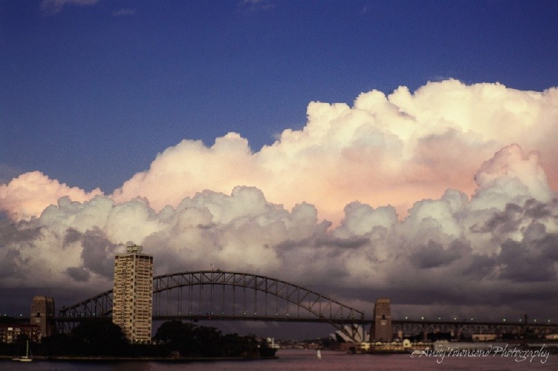 Cloud formations build from the east over Sydney harbour, the harbour bridge and opera house.