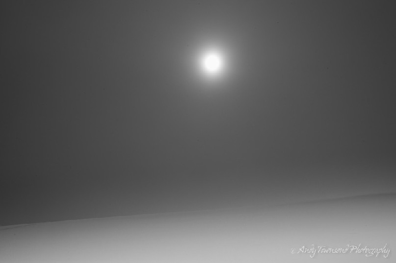 A winter sun breaks  through the cloud to show this snow slope below Tochatadake.
