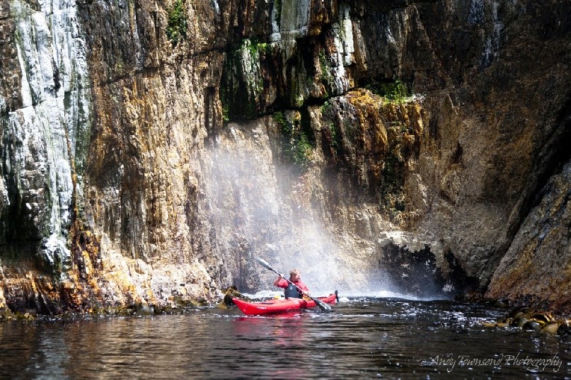 Moving water enters a small cavity and compresses the air inside causing this blowhole to spray a sea kayaker in Southwest Tasmania.