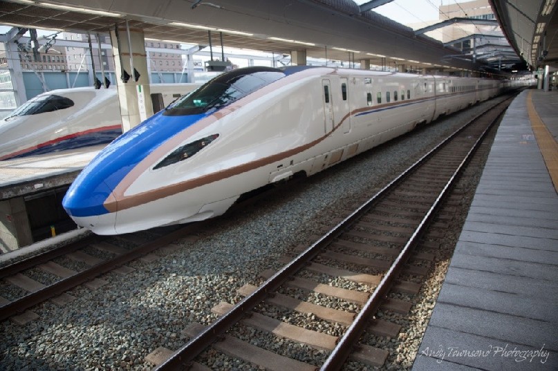 A view down the length of a couple of idle bullet trains from the plaform.