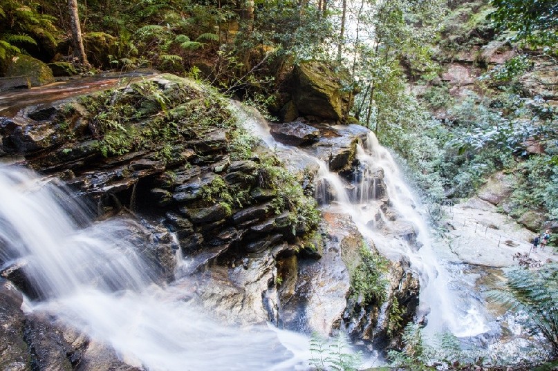 Looking down over water as it cascades down a sandstone escarpment.