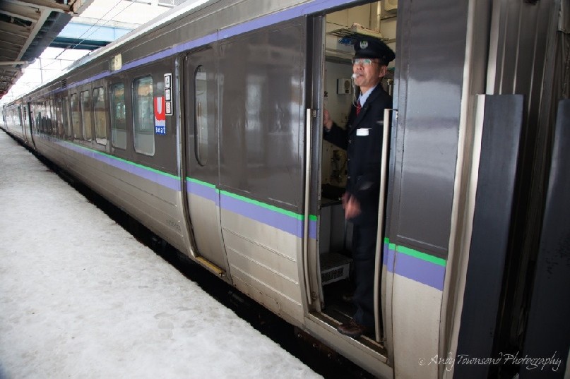 A guard signals the leaving of the train.