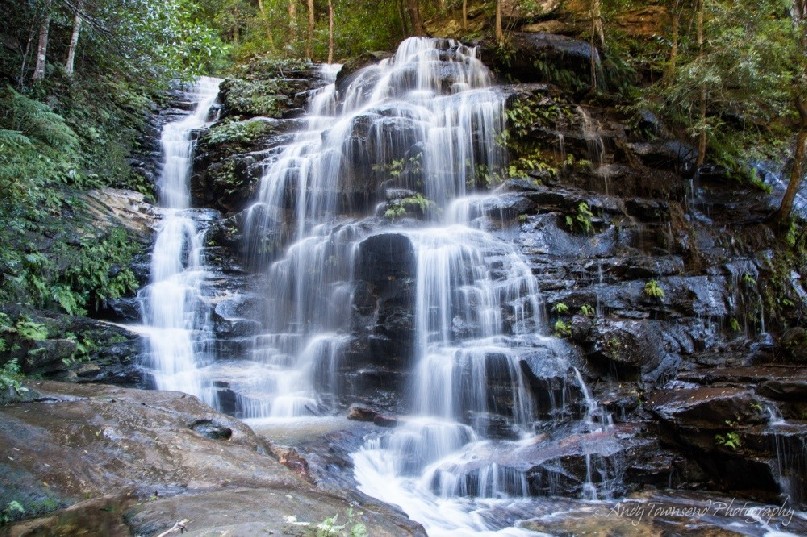 Looking up the falls surrounded by lush rainforest.
