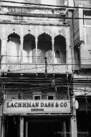 An shop front with old balcony above.