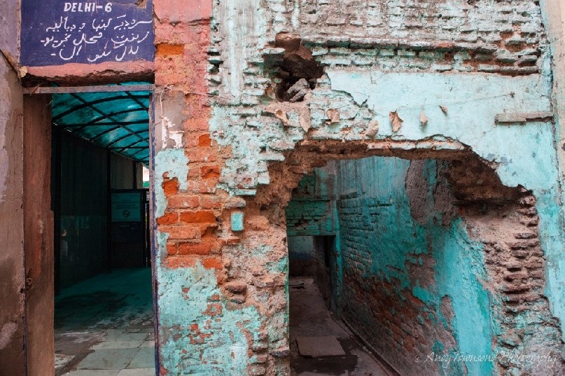 Old bricks show through flaking turquoise paint at the entrance to an all-girl school.