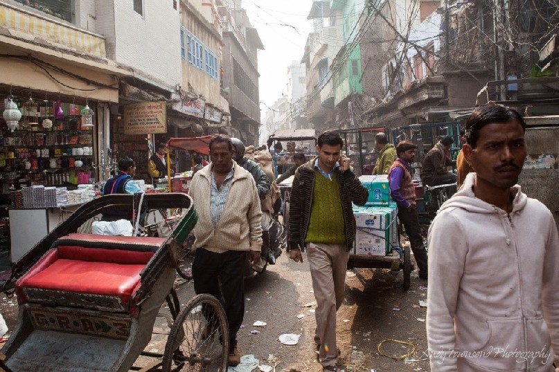 Men walking through a busy  Delhi street.