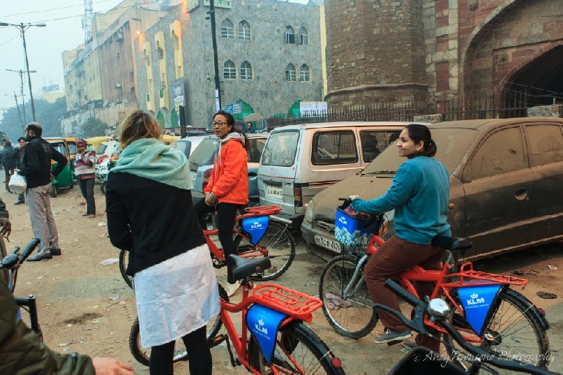 A group of bike riders pauses at the entrance to a fort.