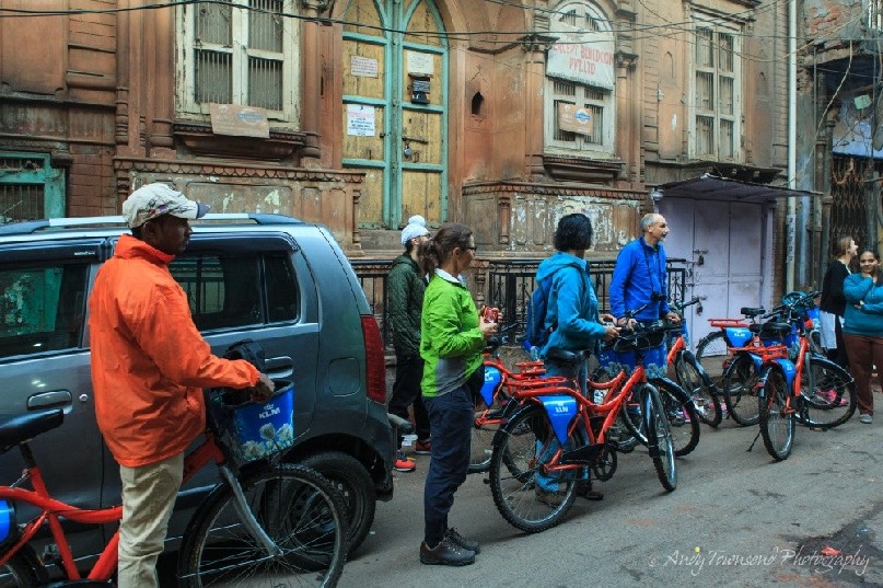 A group of bike riders pauses at the entrance to a shrine.