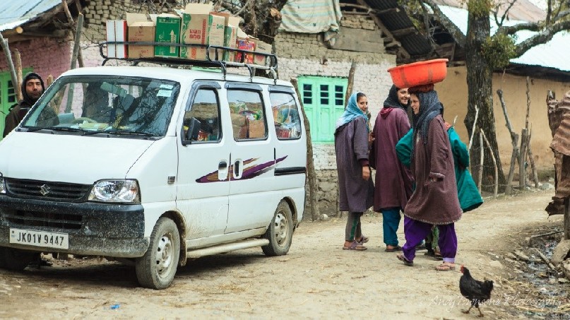 A woman balances a load on her head in the village of Heer.