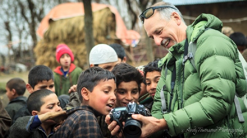 A group of Heer village boys enjoy looking at their portraits on the back of camera.