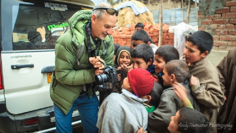 A group of Heer village boys enjoy looking at their portraits on the back of camera.