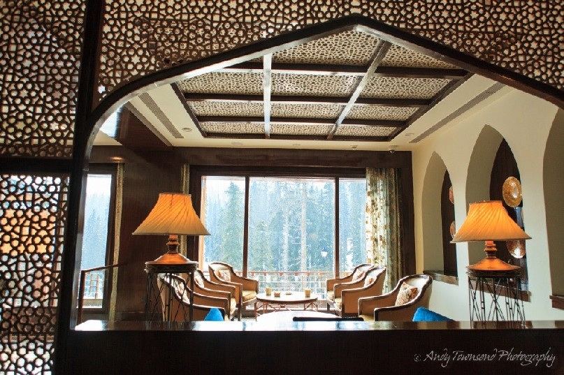 The view over a Khyber lounge looking through an ornate wooden arch.