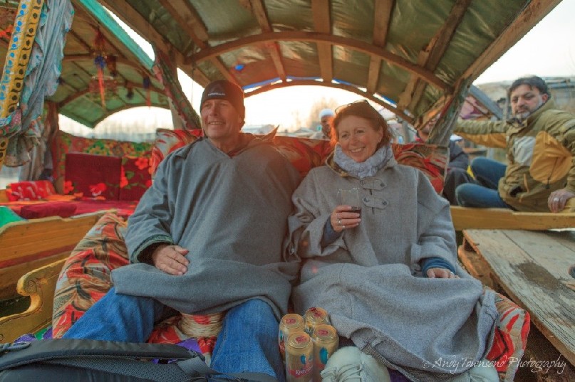 A couple enjoys an evening drink on a Shikara on Dal Lake.