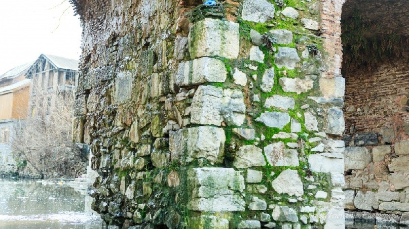 An old stone pylon showing moss in the cracks.