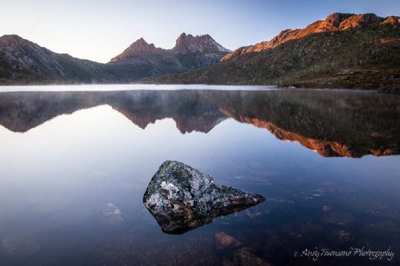 Still waters over Dove Lake with Cradle Mountain catching early morning sunlight.