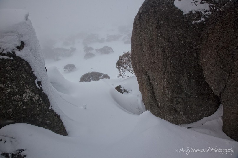 Mist rolls in to envelope the high-country beyond snow-encrusted rocks, Kosciuszko National Park, Australia